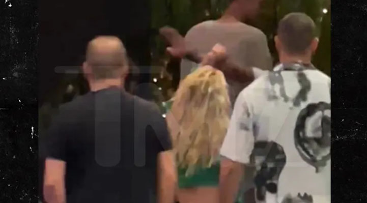 Britney acercándose por detrás a Victor y el seguridad la manotea